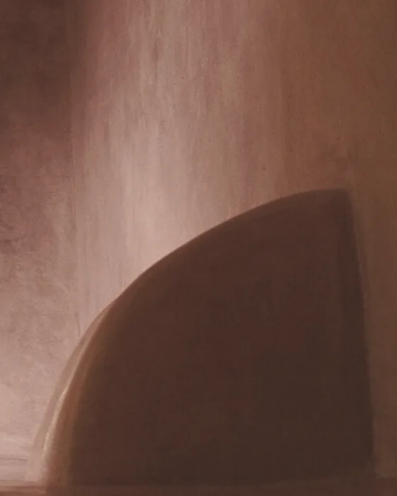 A curved plaster wall in warm, soft light